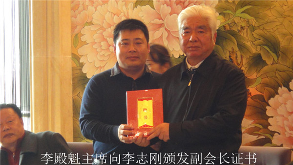 共同主席、山东省政协原副主席李殿魁（右）向副会长青岛尊和集团董事长李志刚颁发证书_-12-20.jpg
